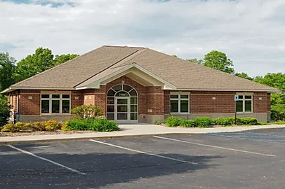 a_brick_building_with_a_parking_lot_in_front_of_it