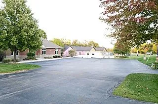 a_parking_lot_with_a_few_houses_in_the_background