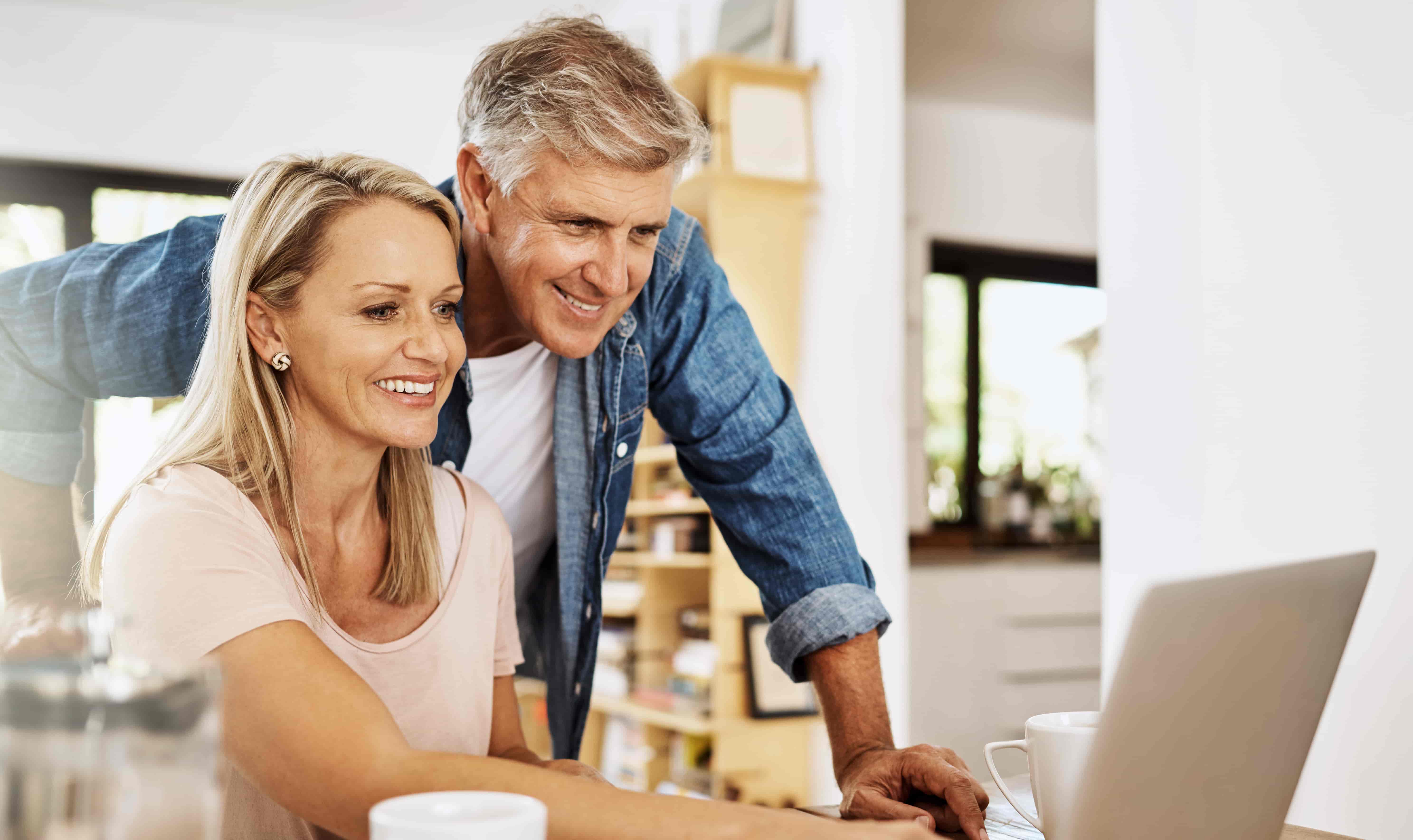 Mature couple, smile and laptop research at home