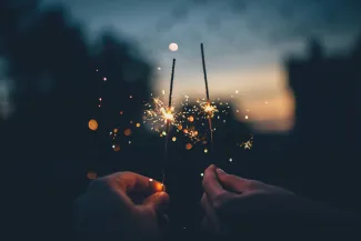 person holding fire cracker shallow focus photography by Ian Schneider courtesy of Unsplash.