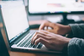 person using MacBook Pro by Glenn Carstens-Peters courtesy of Unsplash.