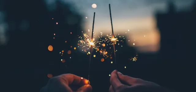 person holding fire cracker shallow focus photography by Ian Schneider courtesy of Unsplash.